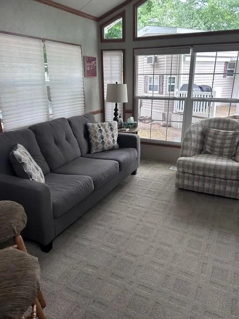 Living room with lots of windows complete with A/c.