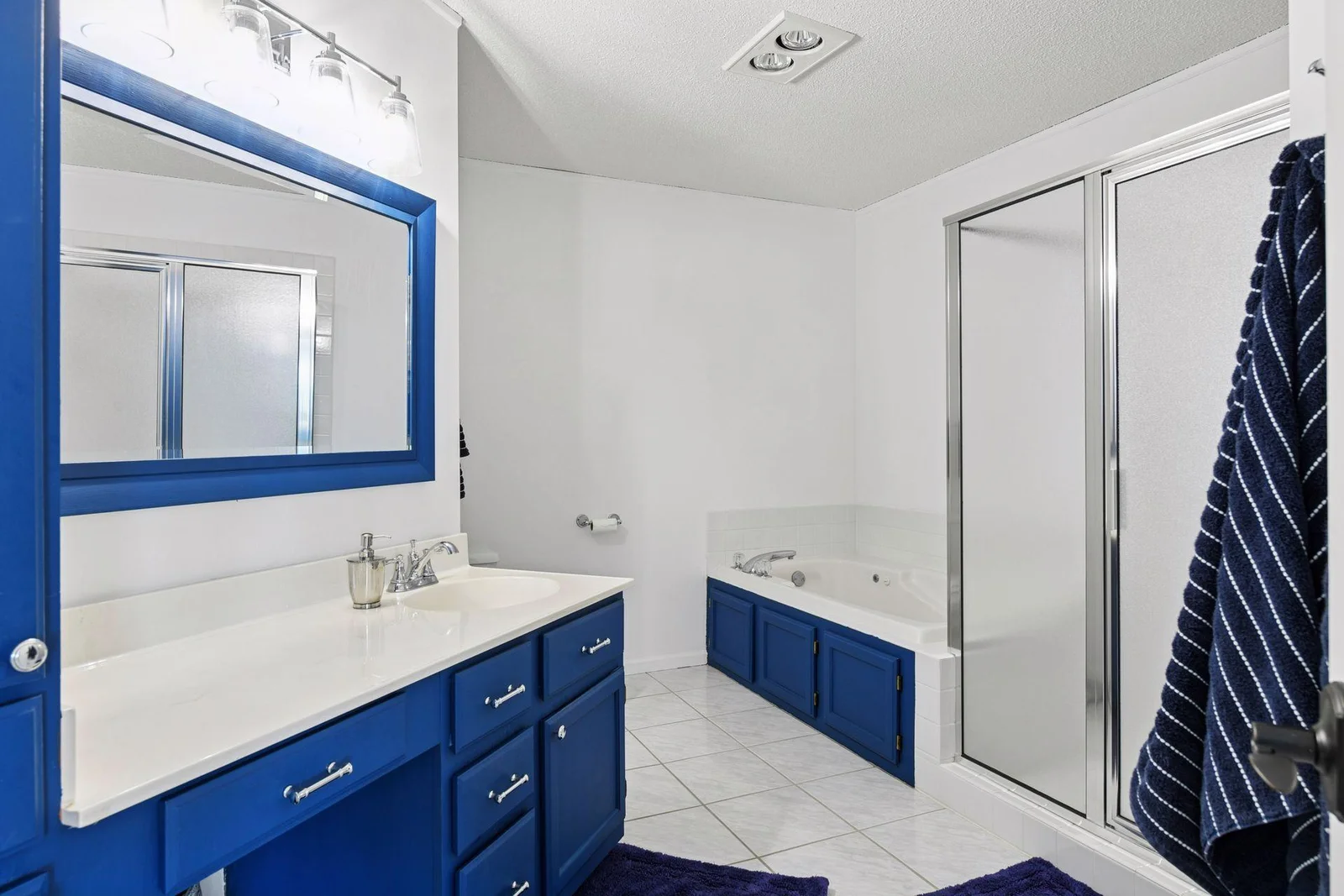 Your own private primary suite bath awaits—featuring a tiled floor, separate jetted tub and shower, and a coastal-inspired vanity for a relaxing, spa-like retreat.