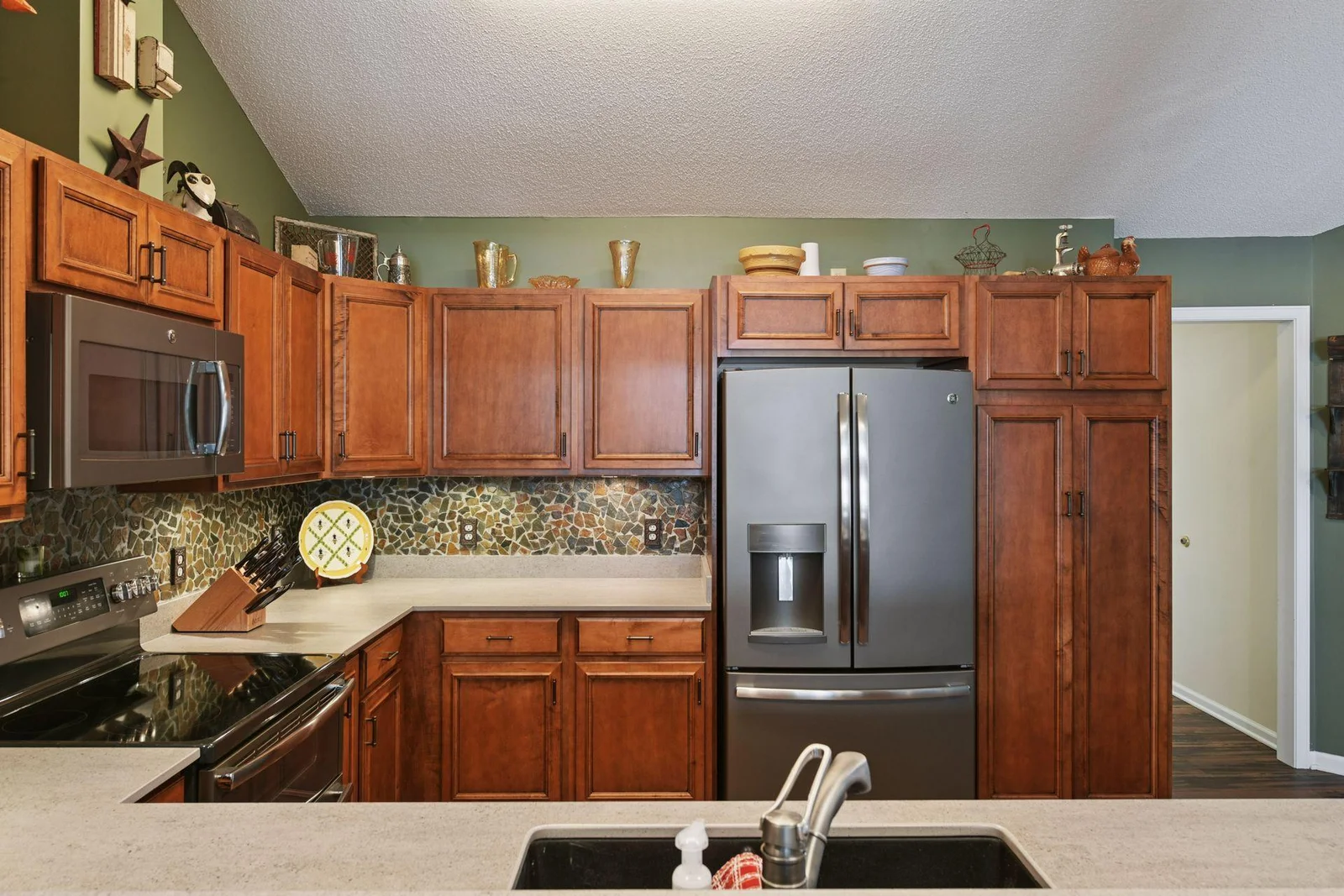 This stunningly updated kitchen features custom cabinetry, new appliances, a stylish stone backsplash, and playful, eye-catching countertops.