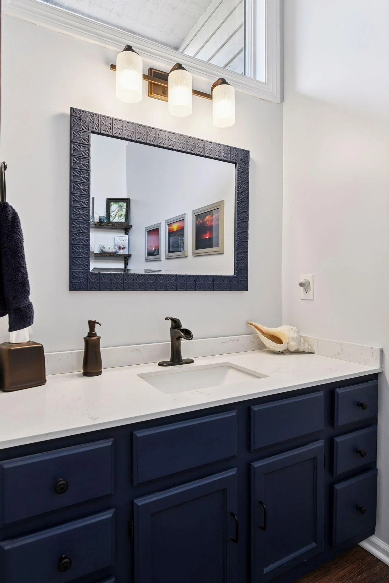 Beautifully updated with coastal flair, the main-level half bath features a transom window that fills the space with natural light.
