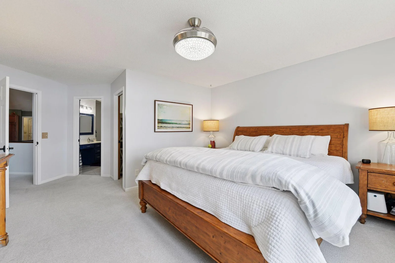 The primary view extends from the lakeside windows into the walk-in closet, through to the full primary bathroom, and out into the main family room.
