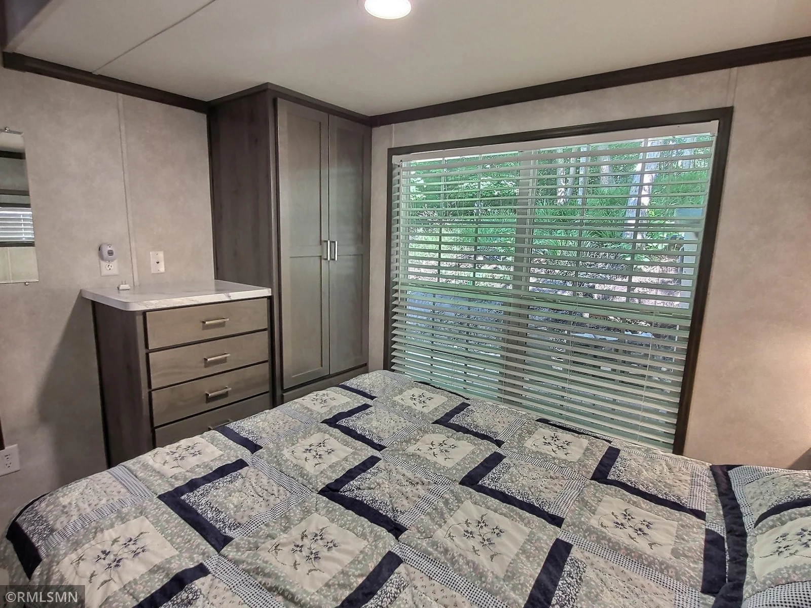 @nd shot of the bedroom showing the cabinet space and the large window for the natural light to flow through.