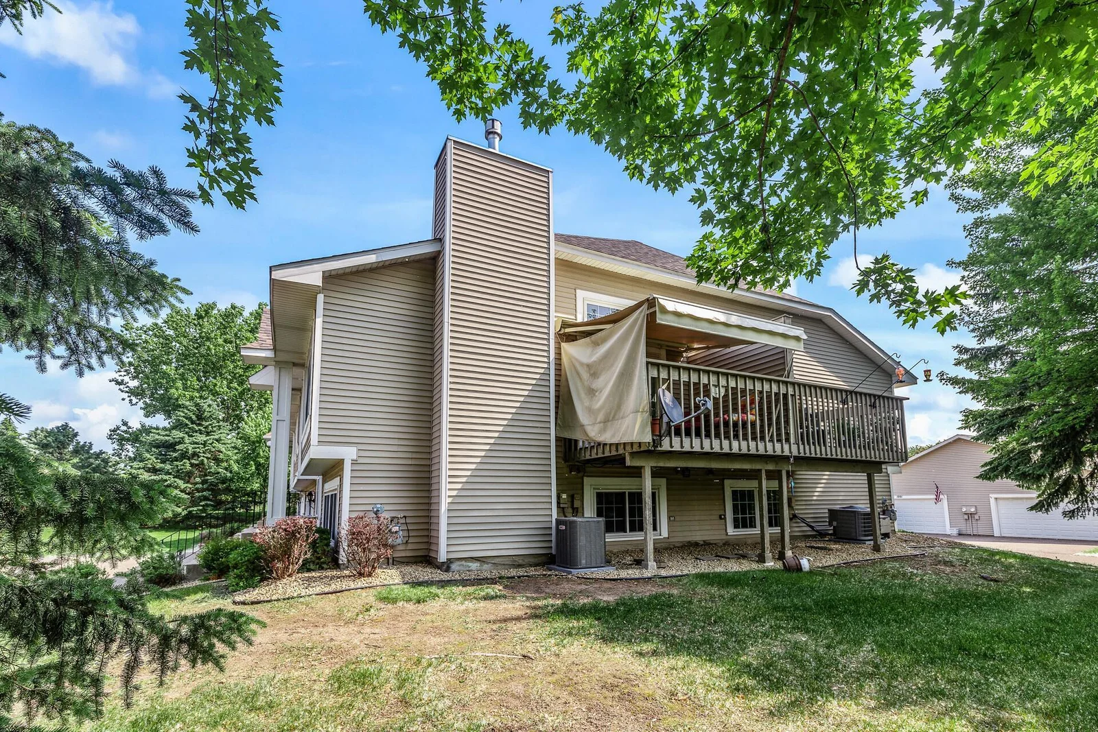 Side of home with retractable awning with privacy sides