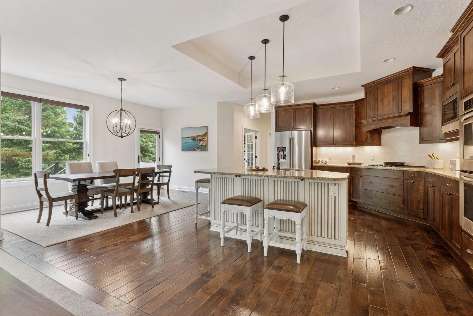 A cozy bump-out informal dining space is surrounded by large windows, flooding the area with natural light. It’s the perfect spot for relaxed meals while enjoying panoramic views of the outdoors.