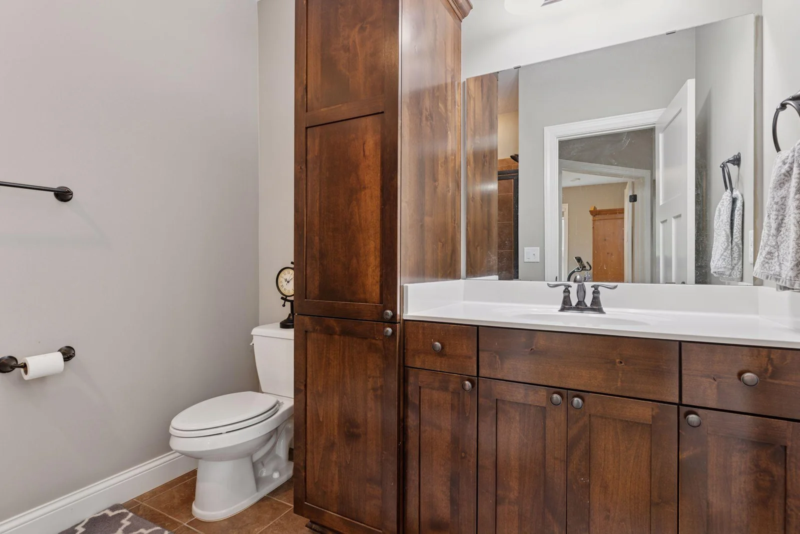 The lower level 3/4 bath showcases stylish cabinetry and elegant tile flooring, creating a polished and inviting space.