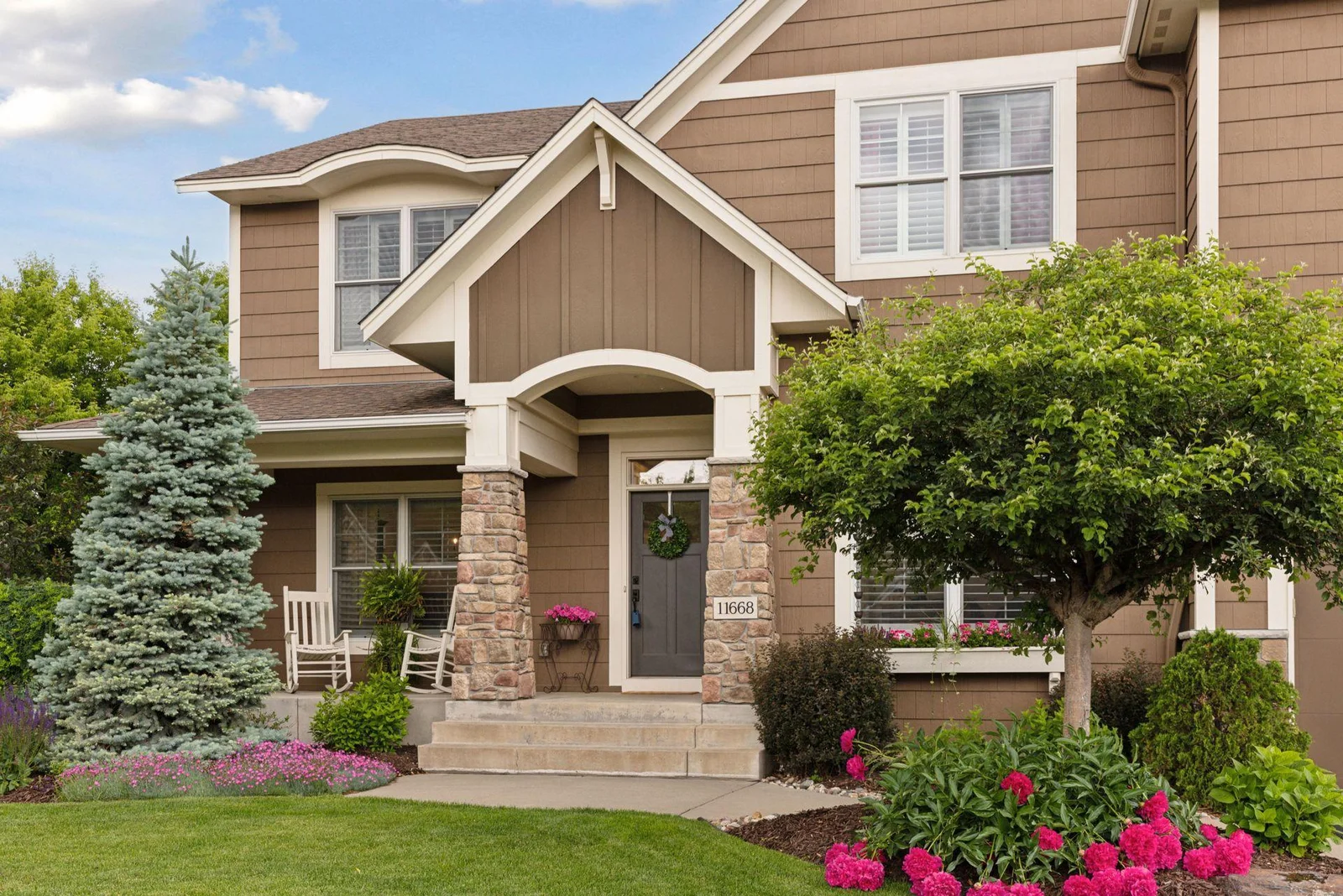As you approach the front door, you’re greeted by beautifully manicured landscaping that sets a warm and elegant tone. Lush greenery, vibrant blooms, and well-placed stone accents create a stunning first impression.