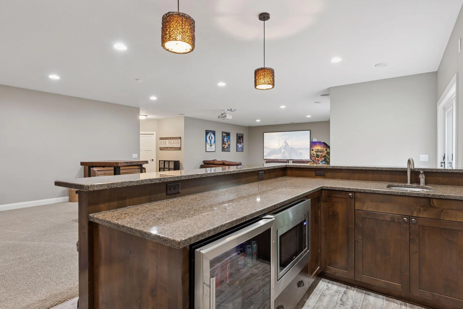 The gorgeous wet bar is a standout feature, complete with a sleek mini fridge, built-in microwave, and polished granite countertops.