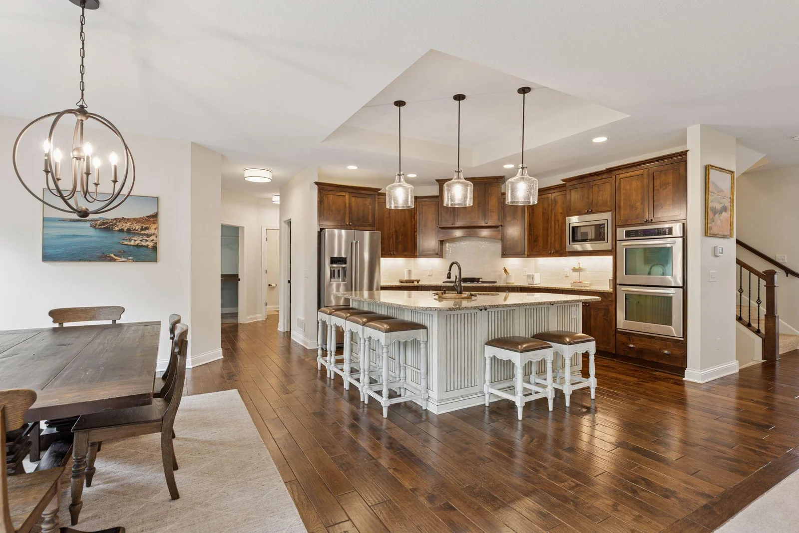The kitchen features a spacious center island topped with sleek stone countertops, perfect for meal prep or casual dining. Its generous size provides ample workspace and adds a touch of luxury to the room's modern design.