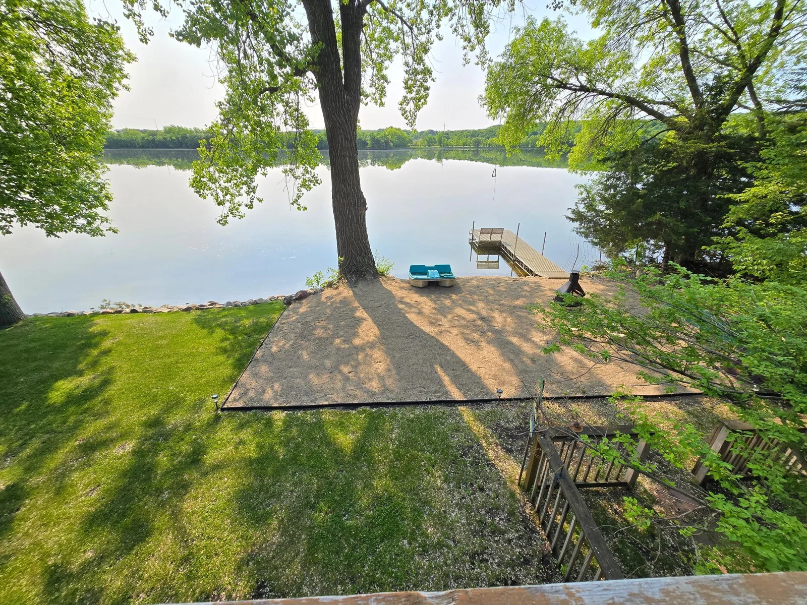 Sandy beach area at the bottom of the deck stairs.