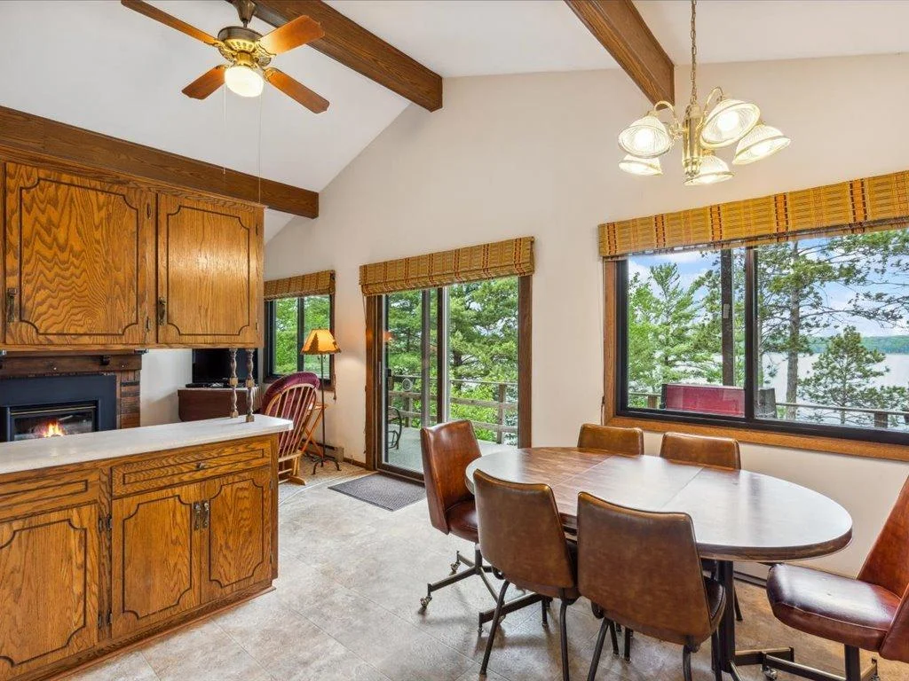Sunlight floods the wood beamed vaulted main level living area with panoramic lake views.