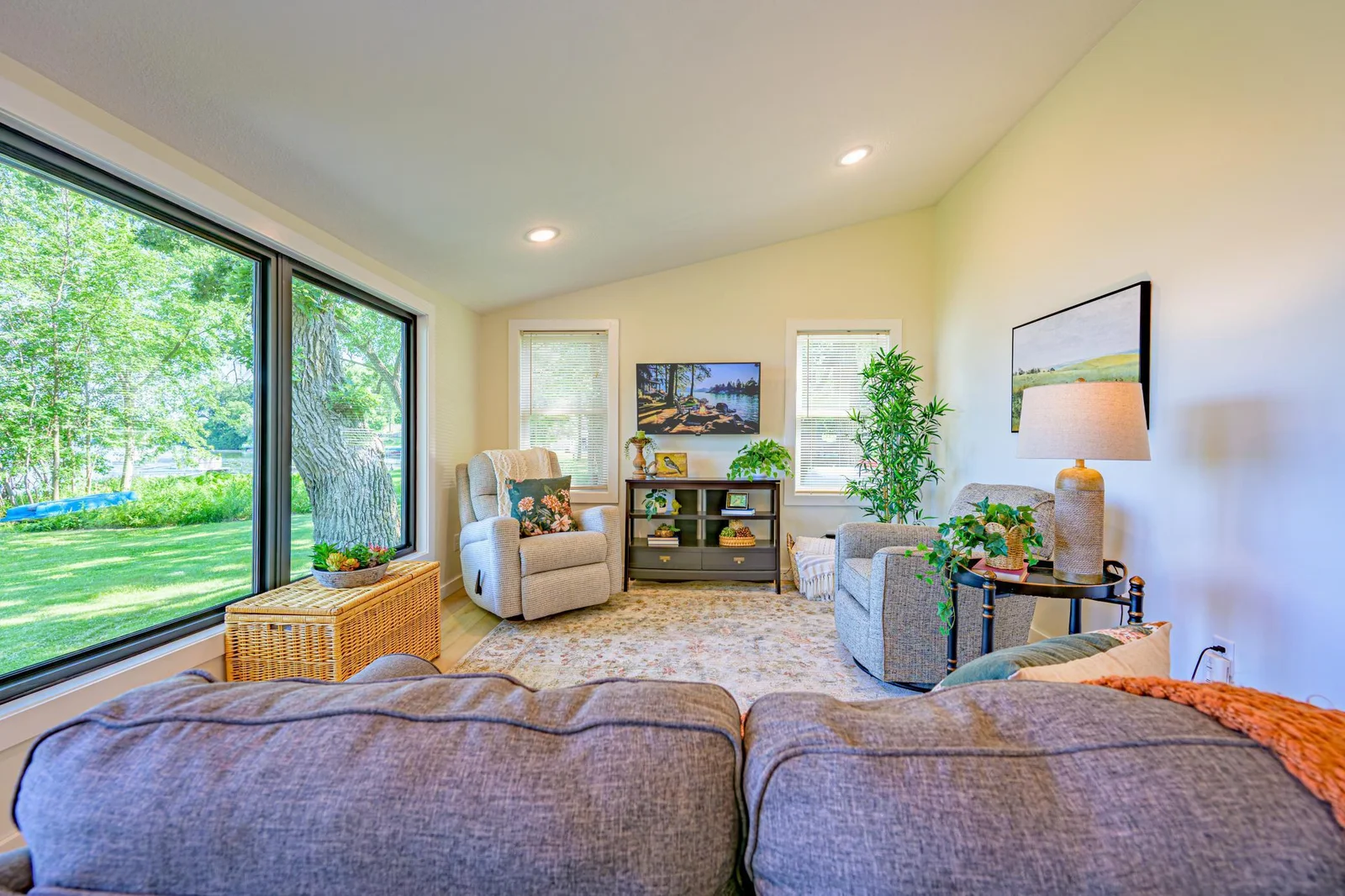 The living room features vaulted ceilings, recessed lights, and large windows overlooking the lake.