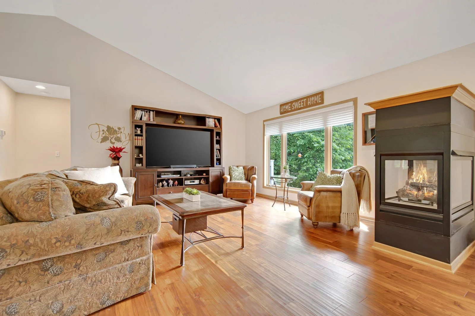 Living room features a double sided gas fireplace and stunning wood floors!