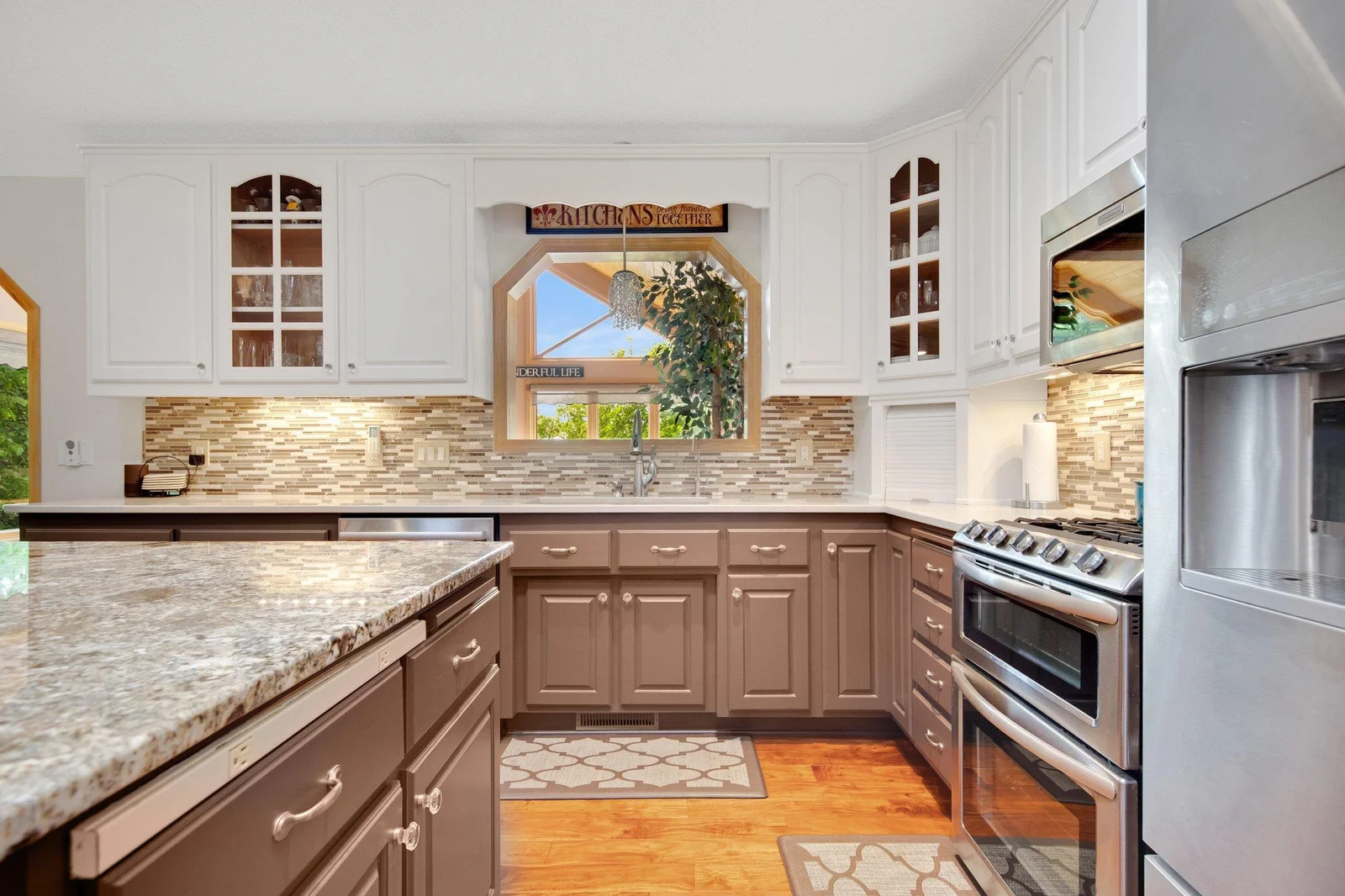 High-end stainless appliance, tile backsplash, and a window looking into the 4 season porch!