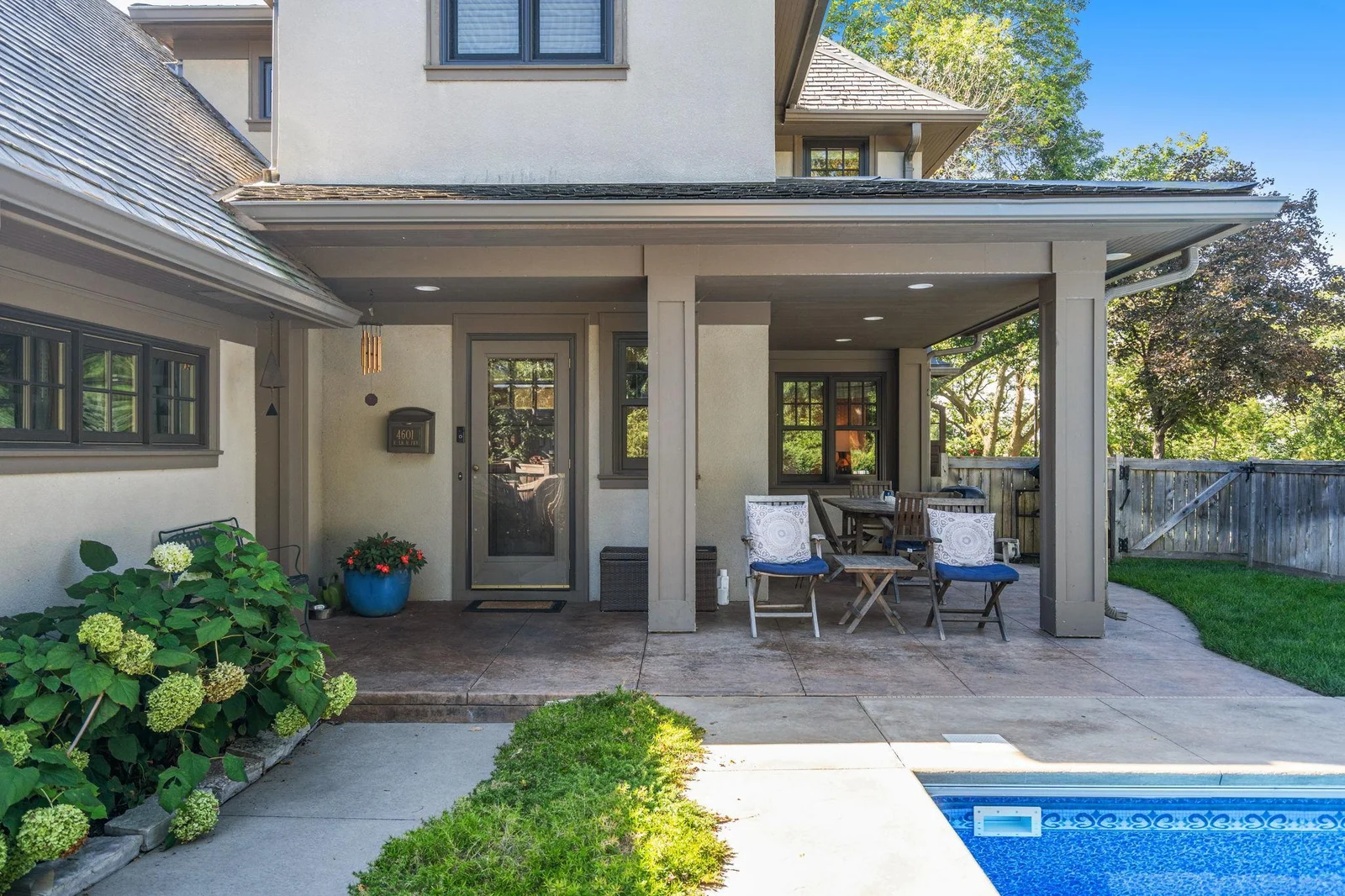 The rear covered porch has space for entertaining and dining poolside.