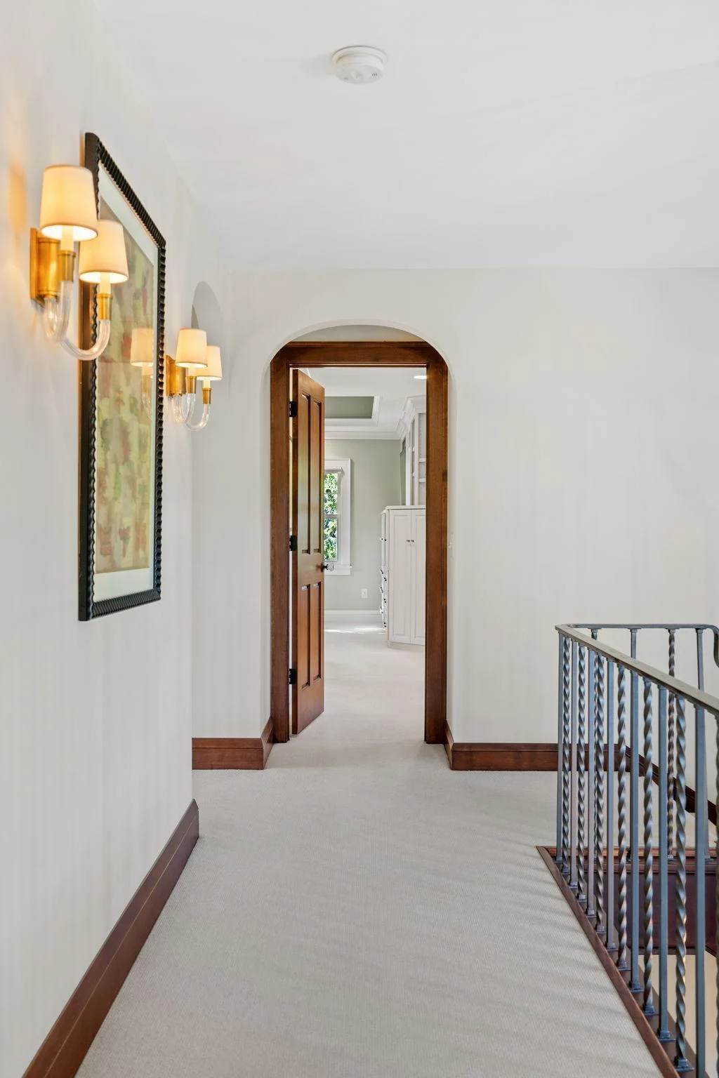 Timeless archways throughout the upper level. The primary suite is located down the hall from the other bedrooms.