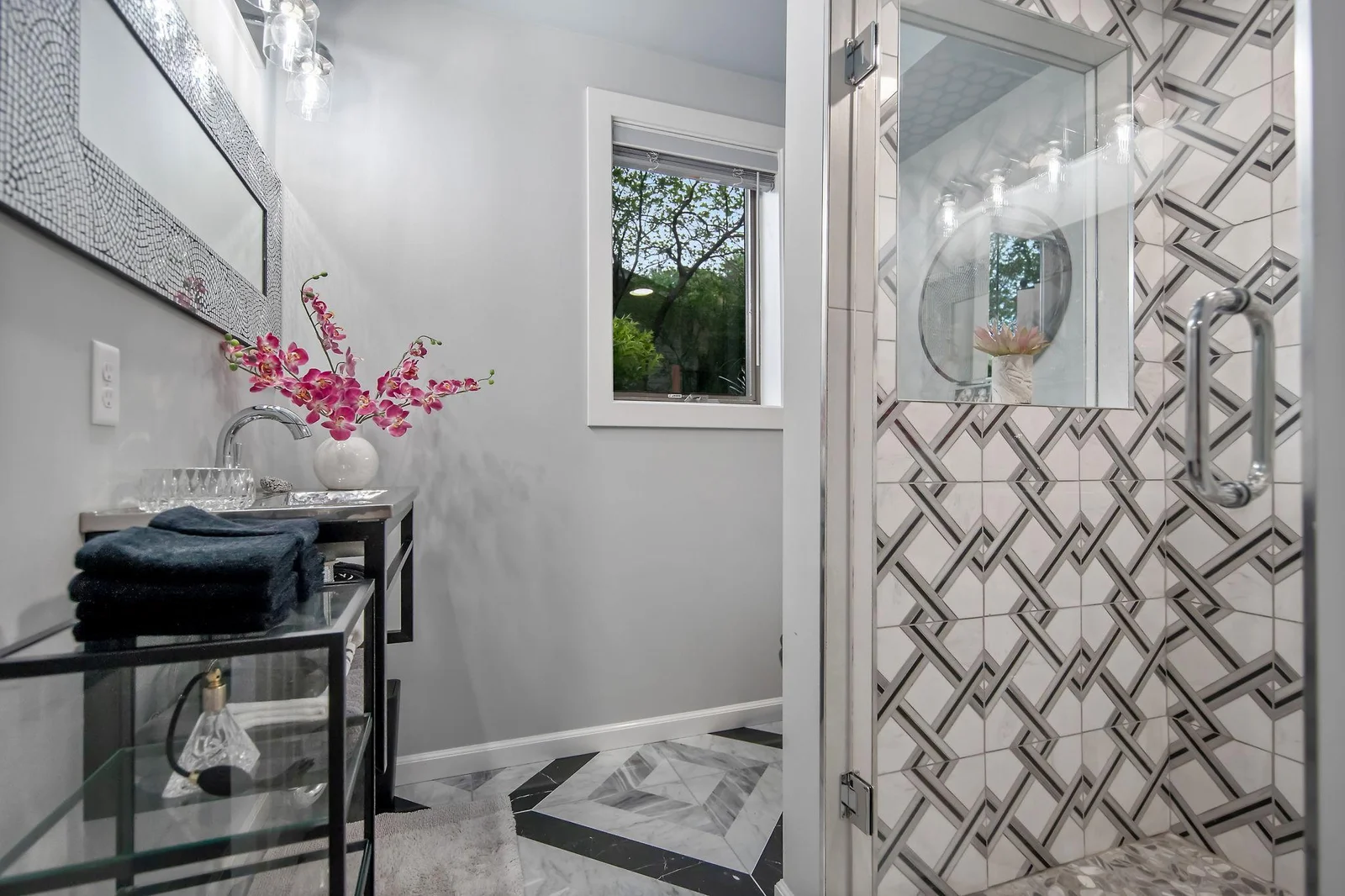 Lower level 3/4 bath with Artistic designed tile floors and shower surround.