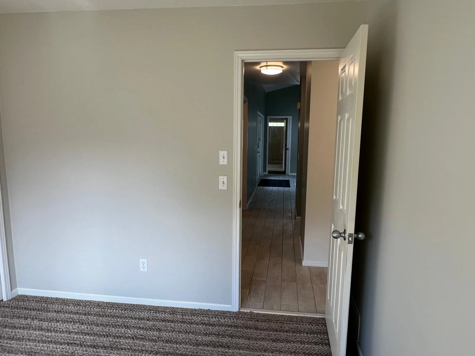 THE VIEW FROM THE MAIN FLOR BR II LOOKS DIRECTLY DOWN THE HALL TO THE PRIMARY BEDROOM.