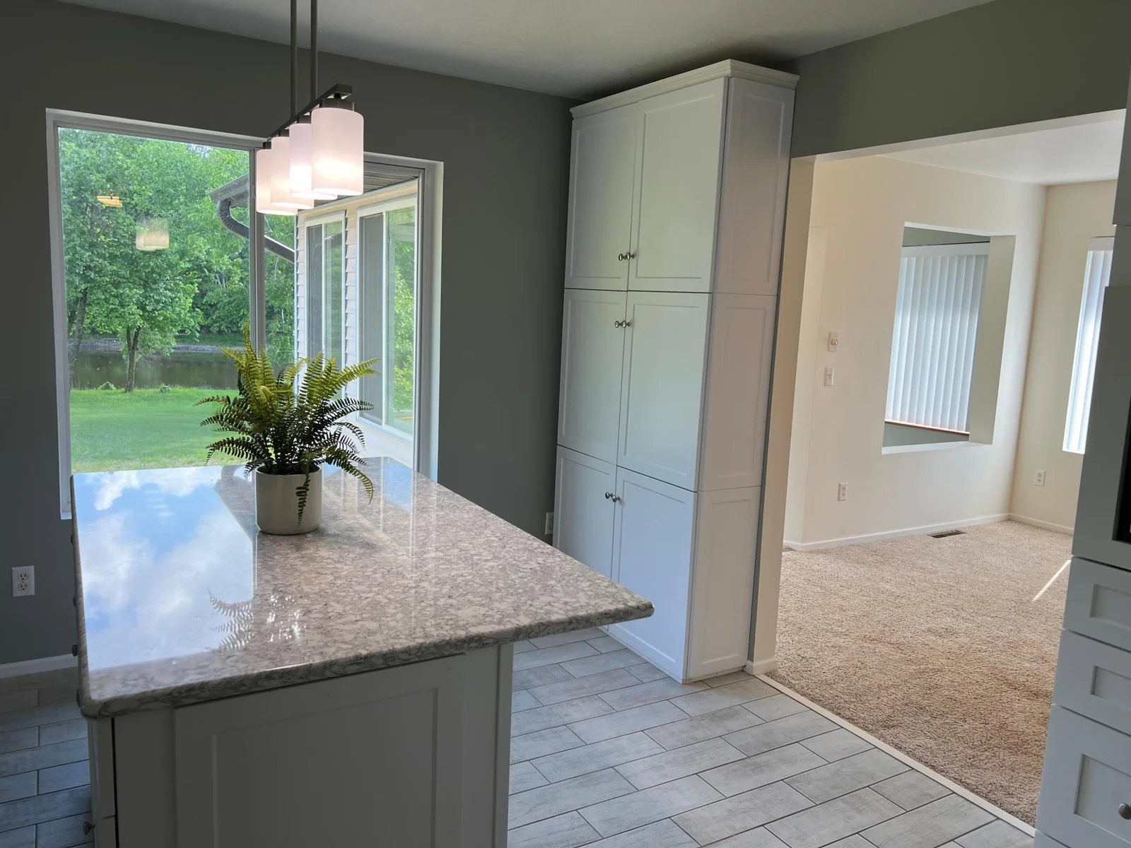 THE KITCHEN ISLAND WITH VIEW TO THE RIVER, AND THE DINING ROOM TO THE RIGHT.