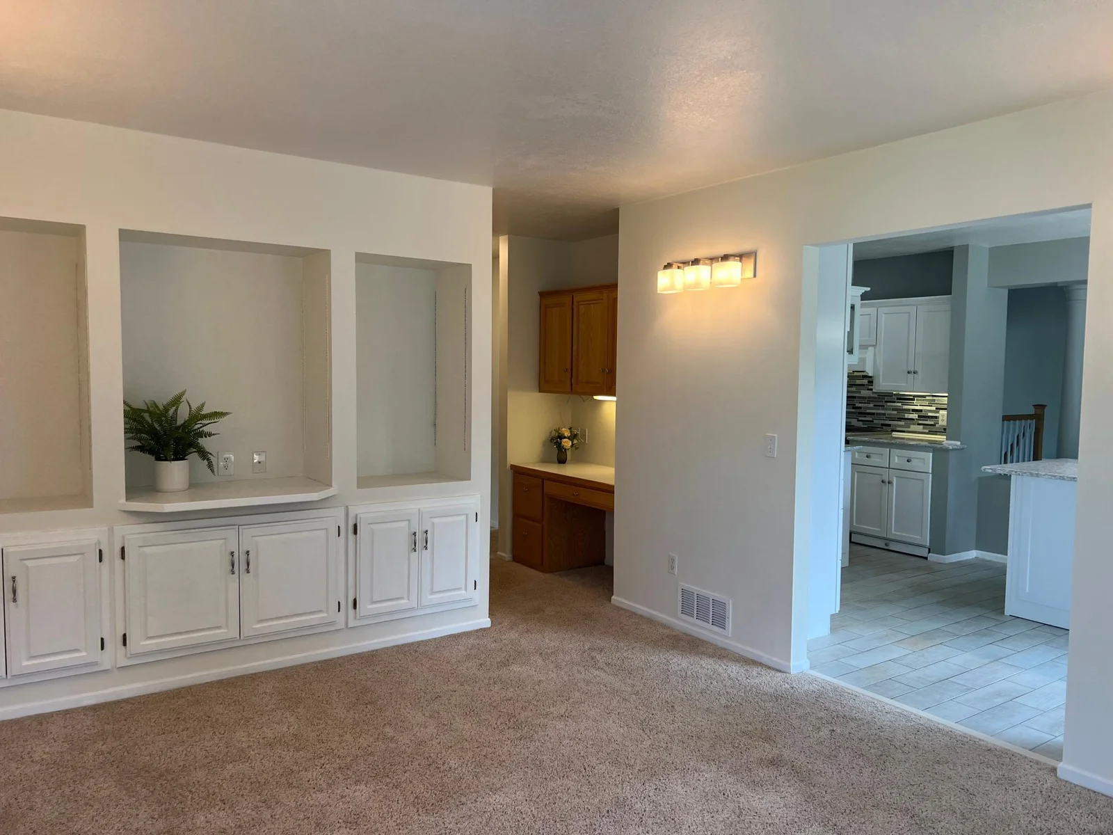 THE DINING ROOM, WITH A VIEW TO THE KITCHEN AND HALLWAY LEADING TO THE BATH & MAIN FLOOR BEDROOM #2.