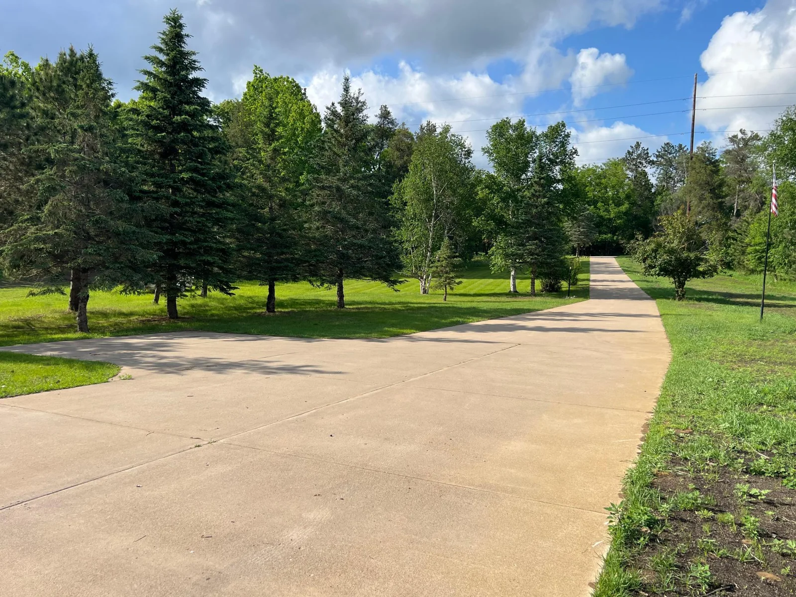 THE LONG DRIVE CREATES A NICE BUFFER FROM THE ROAD; THE CONCRETE PAD DOES DOUBLE DUTY, PROVIDING A PARKING BAY FOR TWO ADDITIONAL VEHICLES FOR OVERFLOW & SERVES AS A TURN-AROUND WHEN BACKING OUT OF THE GARAGE.