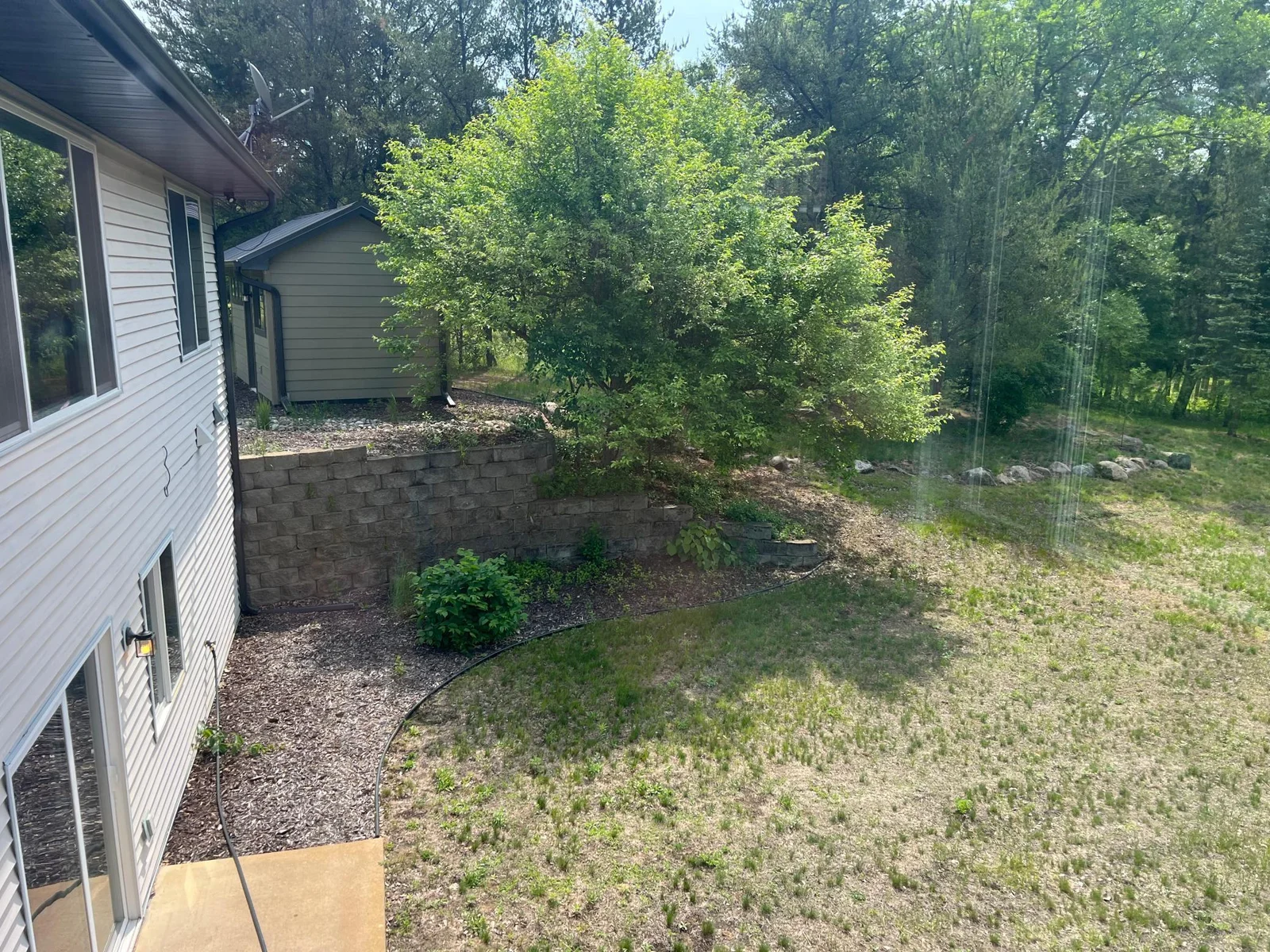 THE VIEW FROM THE SUNROOM ACROSS THE BACK ELEVATION TO THE GARDEN SHED.