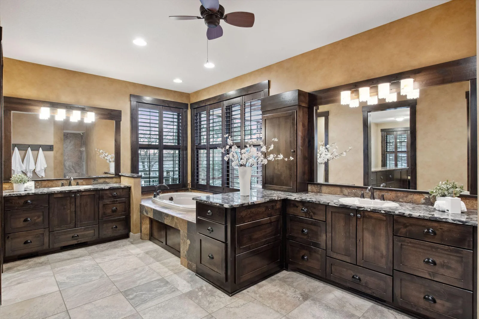 The primary bathroom offers double vanities, extensive cabinetry and comfort height granite counters