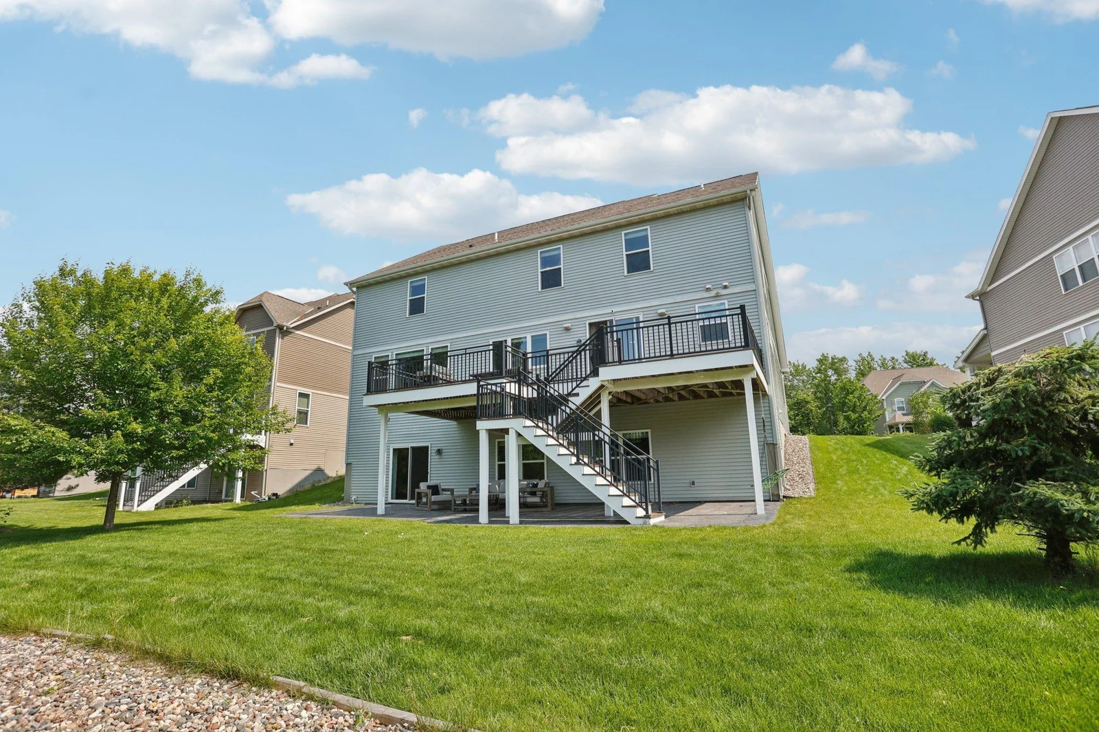 the large, covered patio area offers shaded seating with outdoor furniture—ideal for entertaining or lounging.