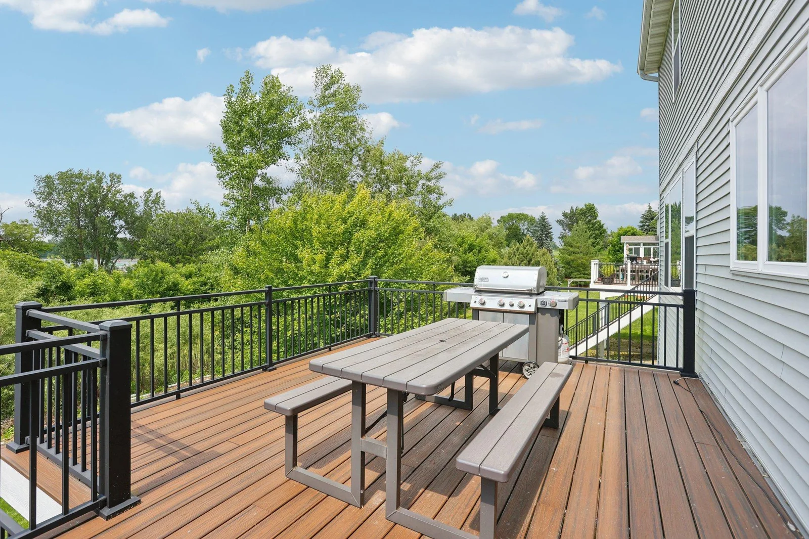 The upper deck is framed with sleek black railings and provides ample space for outdoor dining or relaxing.