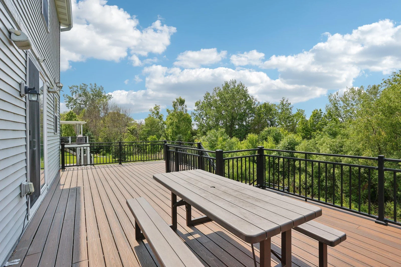 The combination of open green space and versatile outdoor areas makes this backyard perfect for gatherings, play, or peaceful retreat.