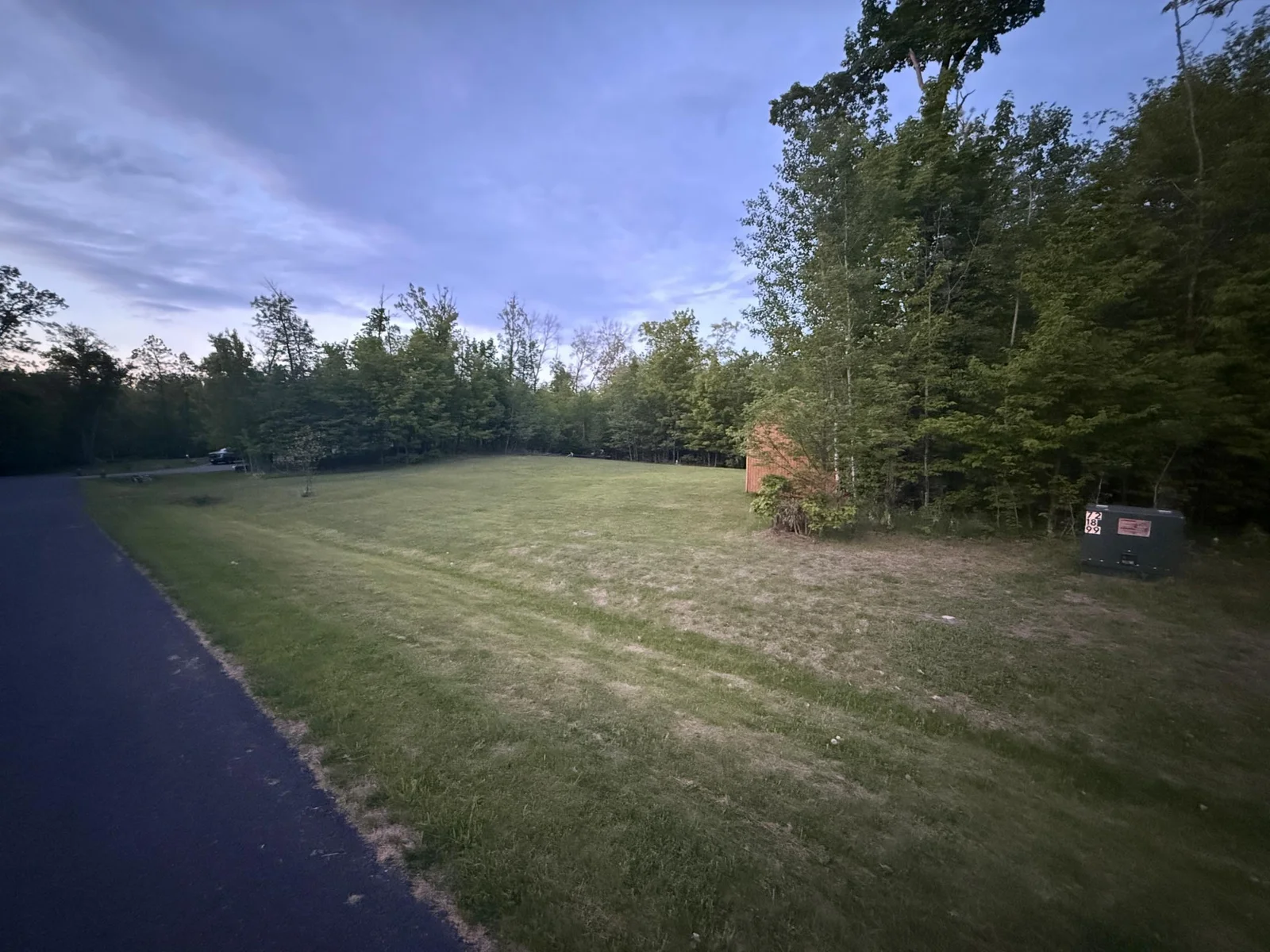 large yard with shed to left of house