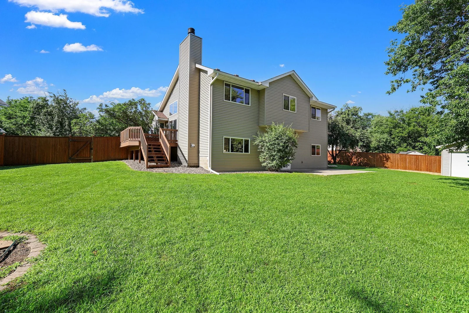Side deck leads to a flat backyard