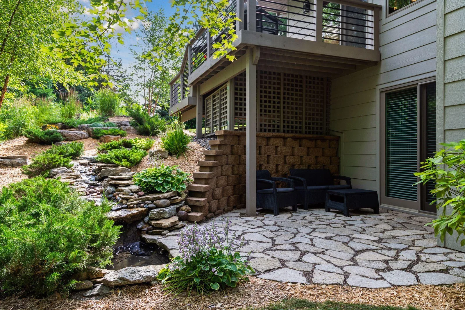 The walkout lower level leads to a thoughtfully landscaped patio, complete with stonework, a tranquil waterfall, and a charming pond with fish.