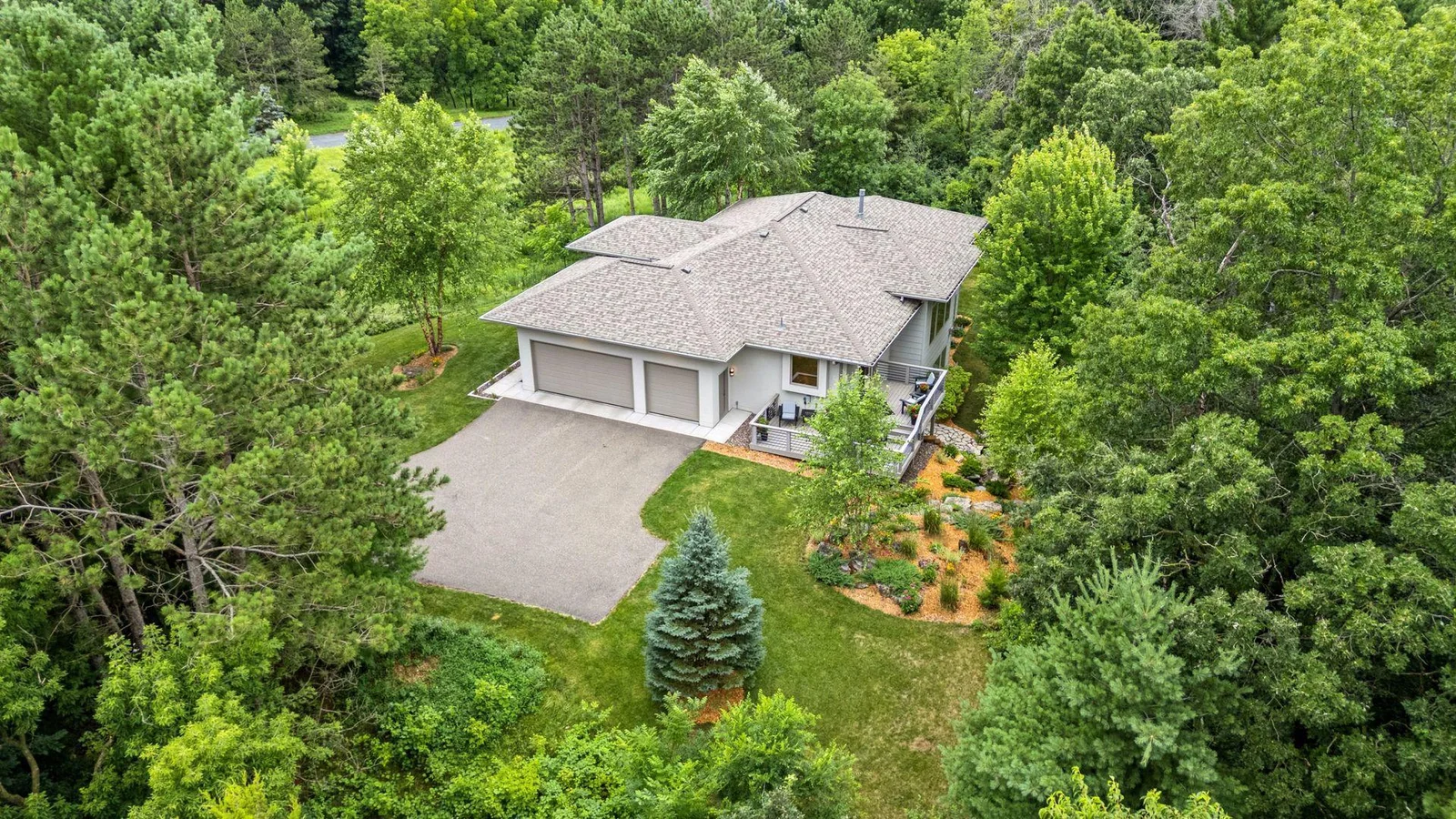 The three-car garage is framed by just the right touch of low-maintenance landscaping.