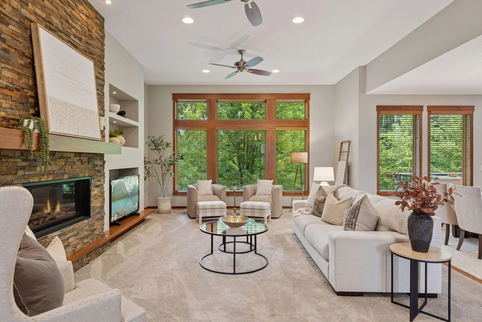 A cozy living room featuring a modern gas fireplace with stone surround and built-in shelving.