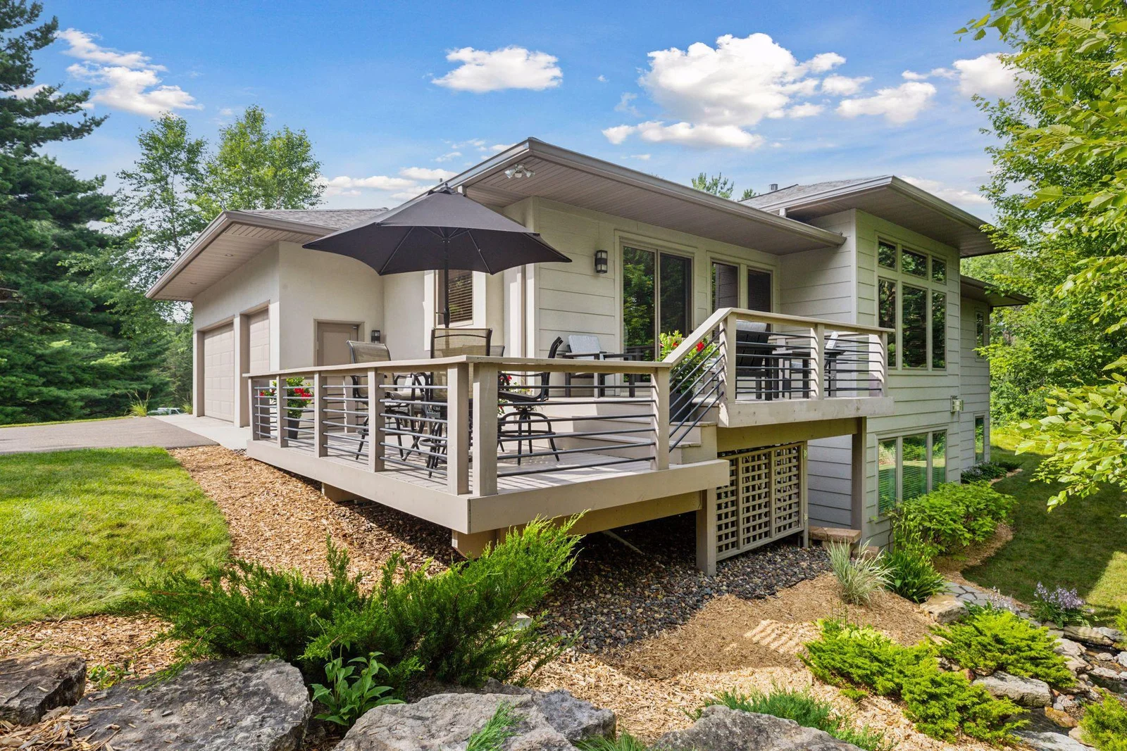 A view from the backyard highlights the home’s sleek, modern lines, contemporary railing details, and a harmonious mix of stucco and cement board siding.