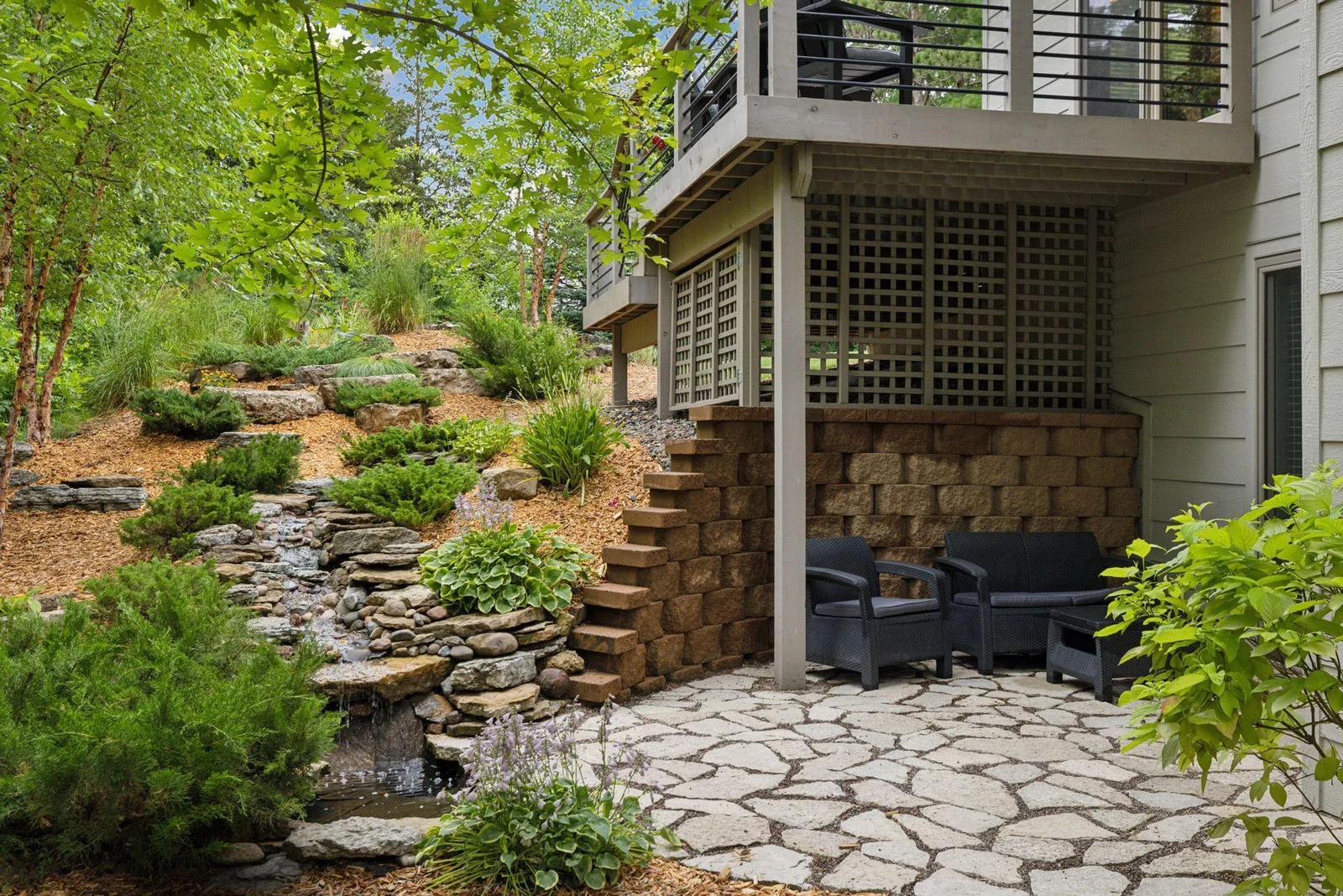 Step out from the lower level to this peaceful patio, complete with a waterfall and pond that bring soothing sights and sounds.