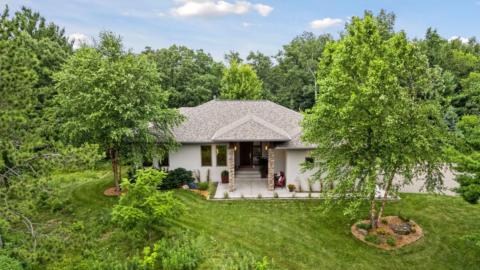 Aerial view of the bold front entry and sleek architecture set against lush surroundings.