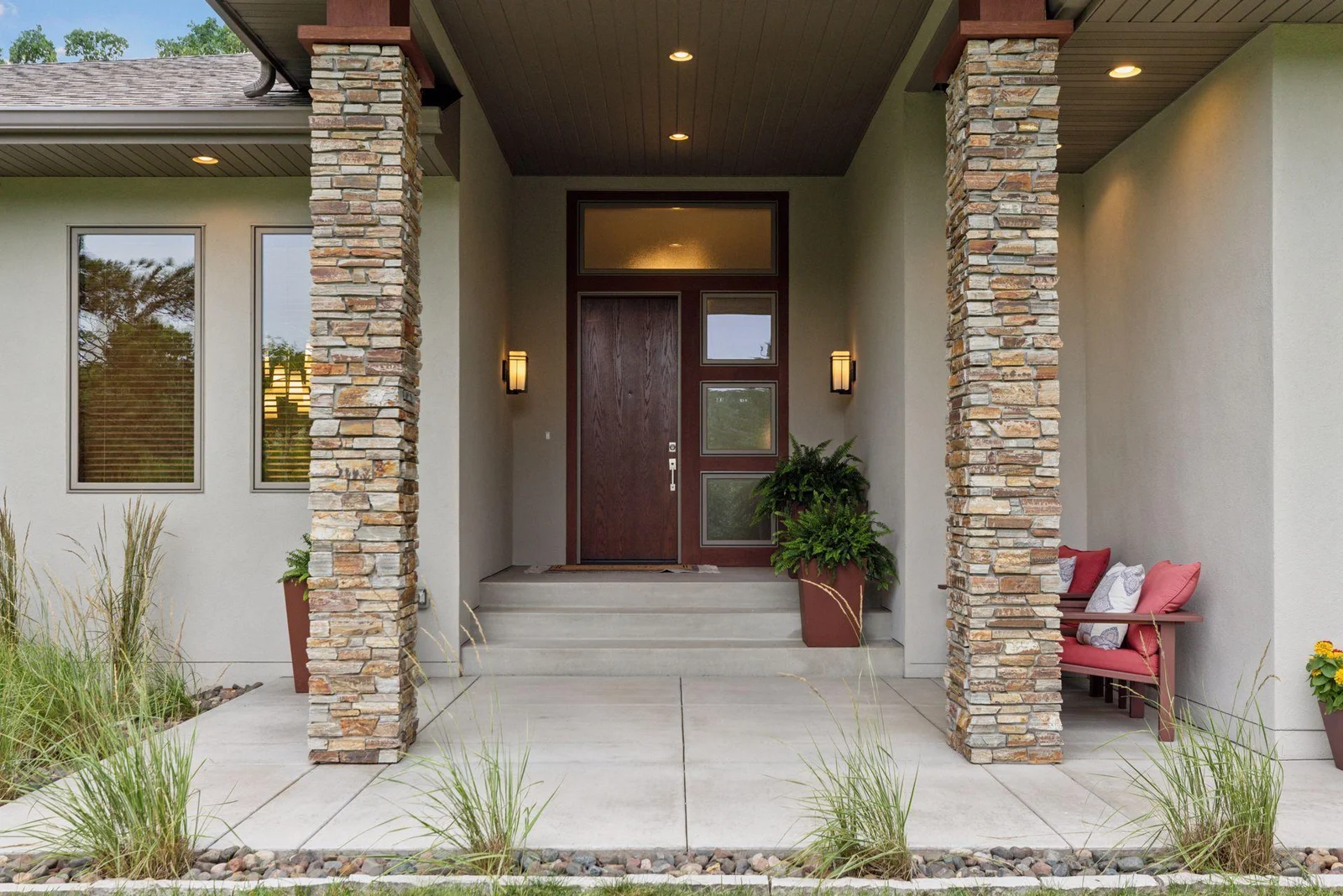 Welcome to your modern front entry—stone beams, a sleek front door, and serious wow factor.