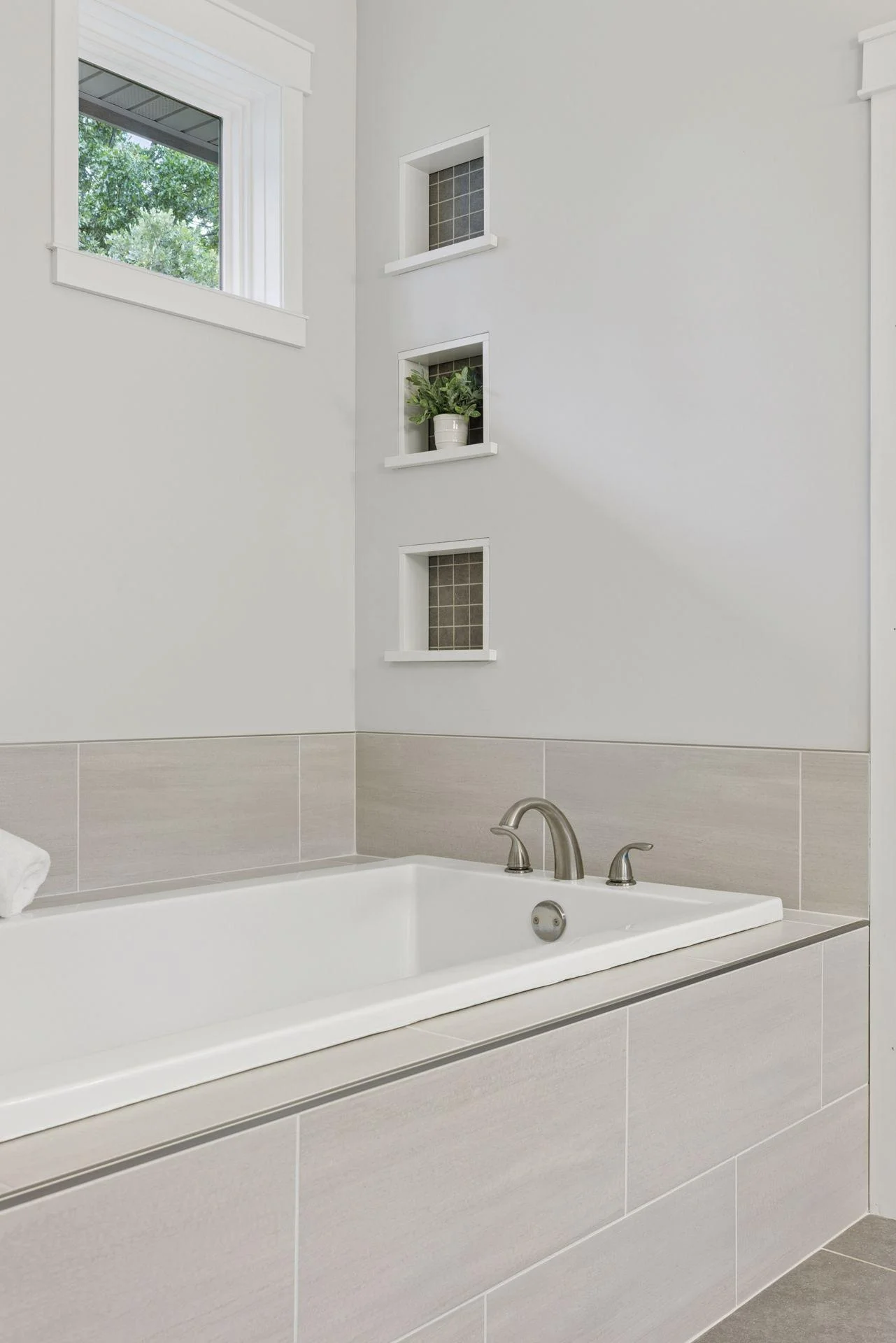 A spa-like soaking tub with custom tile details and recessed shelving.