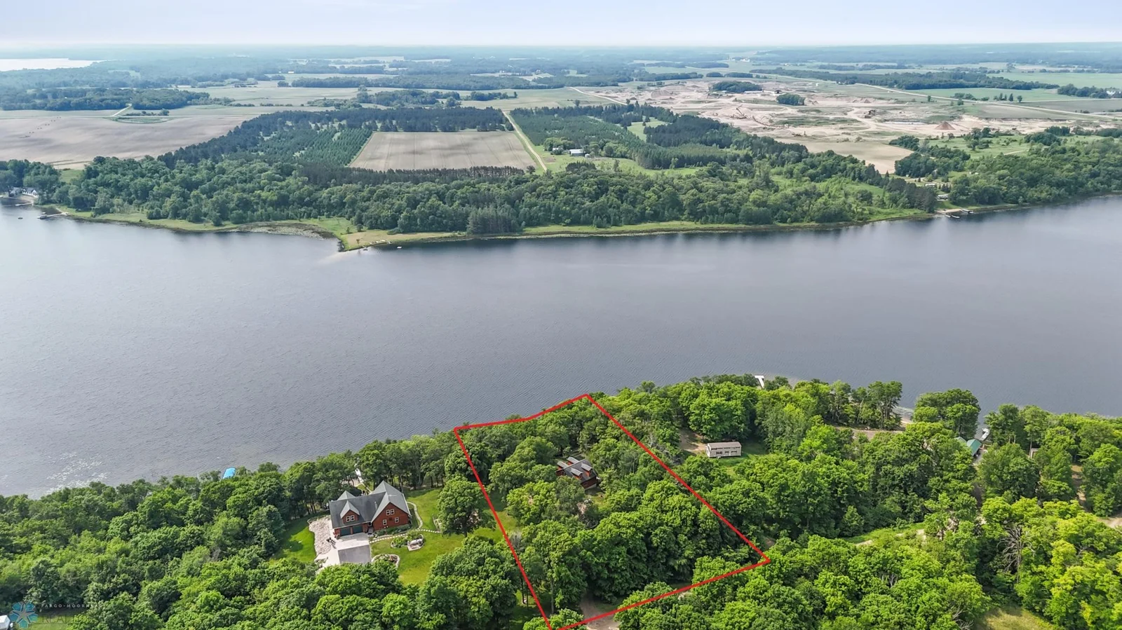 Areal view of lake, cabin, and nearby area