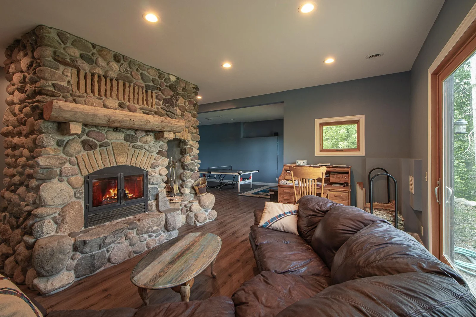 16 x 12 Lower-level family room with floor to ceiling wood burning fireplace