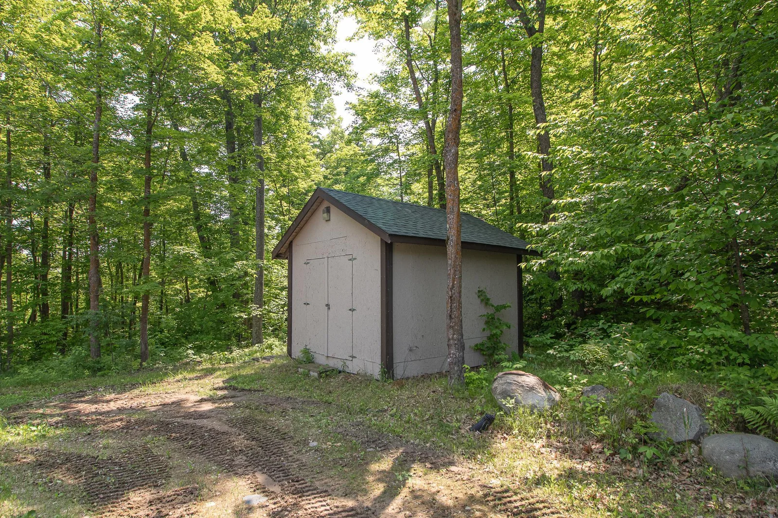 Storage shed behind detached garage