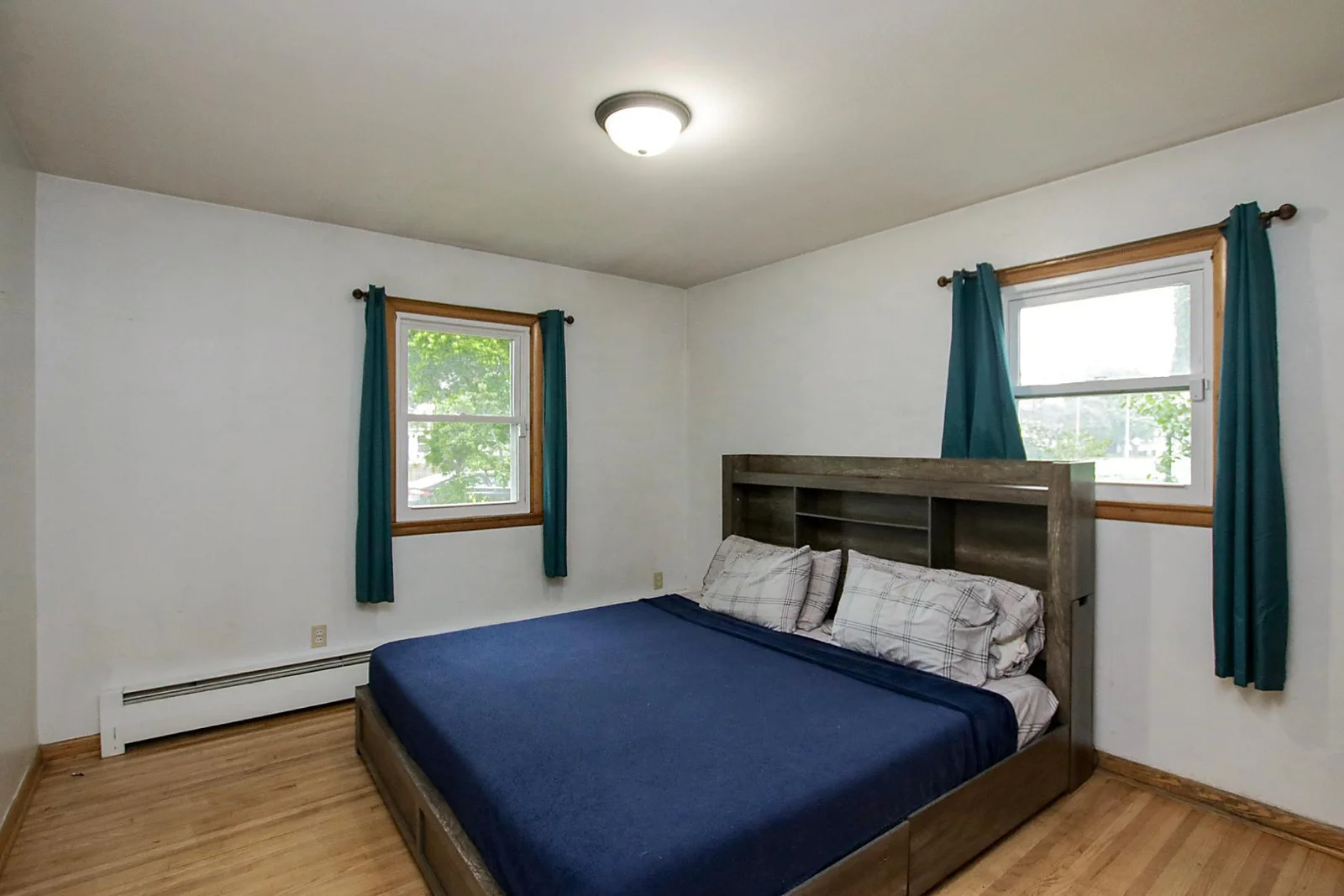 Main floor bedroom is large enough for a king size bed, notice the pretty wood floors!