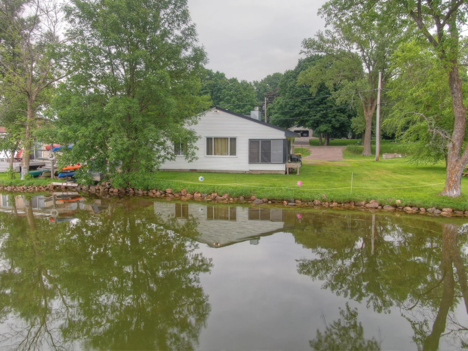 Hard to find home with no steps down to the water and located just feet from the natural rock/sand bottom shoreline. After 55+ years in the same family now it is time for someone else to start making memories at Lake John!