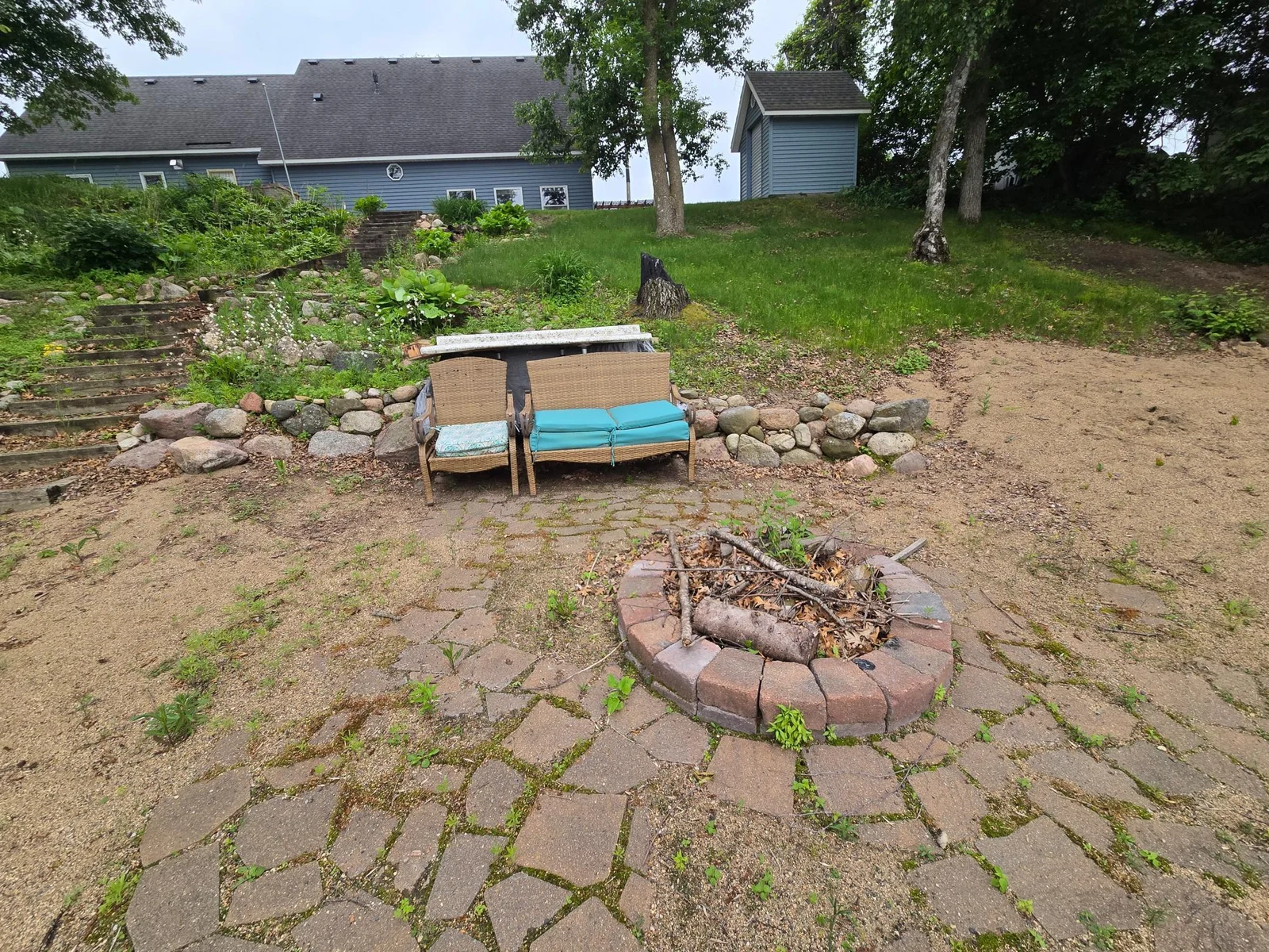 Steps down from the house to the sandy beach and firepit