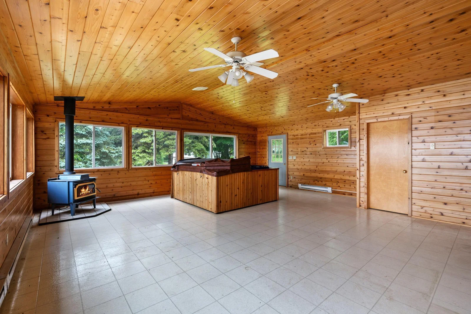 Sunroom has wood burning stove and backyard access