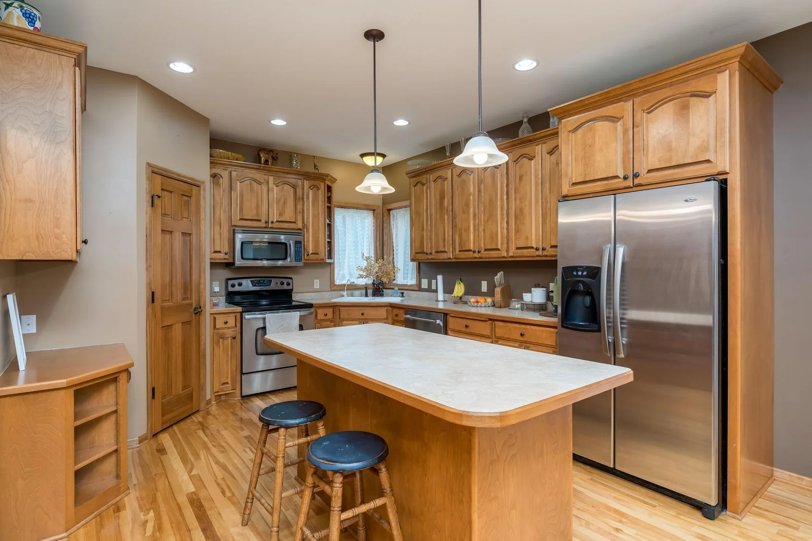 Nice kitchen with large center island, beautiful raised panel cabinets, walk-in pantry and stainless steel appliances.
