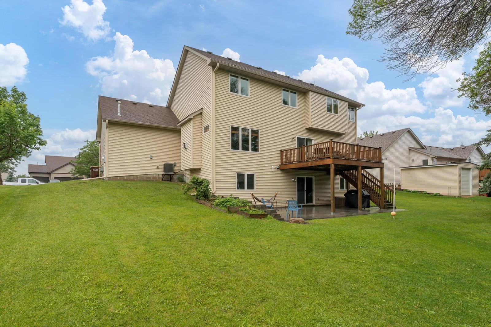 Nice yard to run around on - lot goes back to the trampoline.  Back view of the home w/ large deck & stamped concrete patio!
