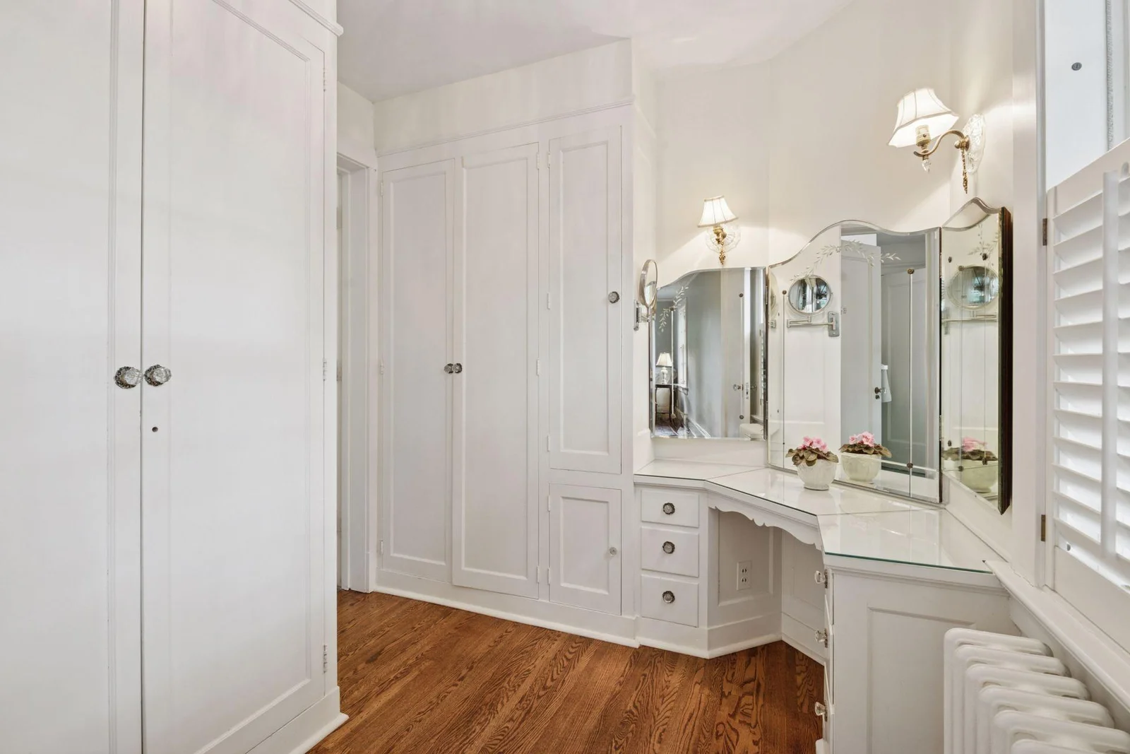 The primary dressing room has wardrobe closets and a make-up area.  Don't miss the crystal knobs and beautifully arched mirrors.