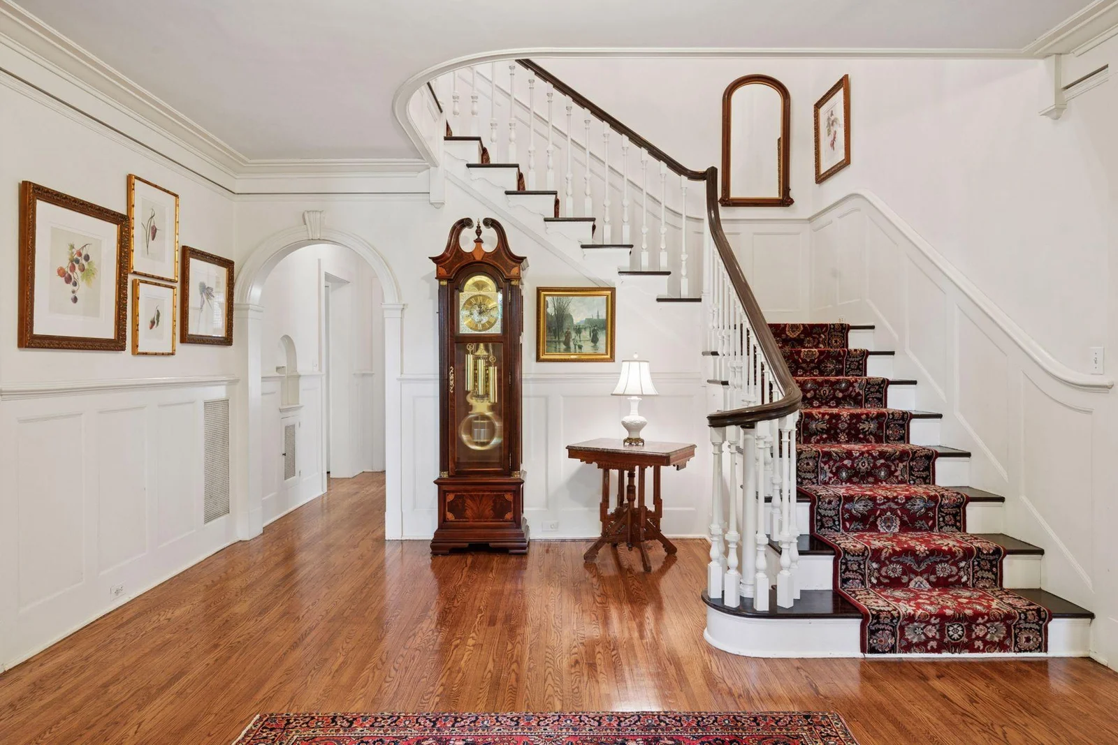 The foyer is rich in detail: the arched doorway, crown molding, and wainscoting.